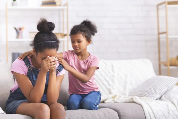 Pequena menina africana confortando sua irmã adolescente chorando com problemas de relacionamento — Fotografia de Stock