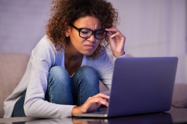 Laptop kullanan kötü görüşlü Afro-Amerikalı kız öğrenci.