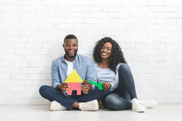 Renkli plastik ev ve anahtar taşıyan Afrikalı çift — Stok fotoğraf