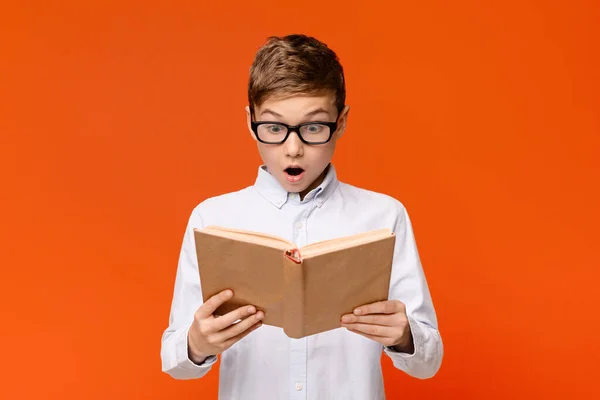 Niesamowity nastolatek nerd w okularach emocjonalnie czytania książki — Zdjęcie stockowe