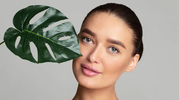 Hermosa mujer con piel limpia y hoja verde — Foto de Stock