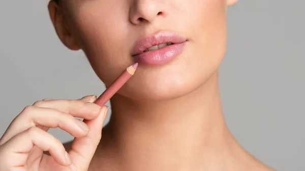 Woman drawing lips with nude pink lipliner — Stock Photo, Image