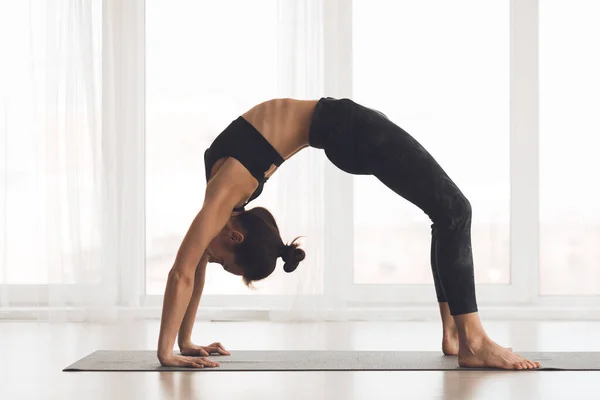 Ung kvinna som tränar yoga i Bridge Pose — Stockfoto