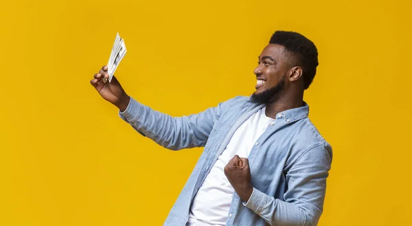 Overjoyed black man celebrating success with dollar bills in hand — Stock Photo, Image