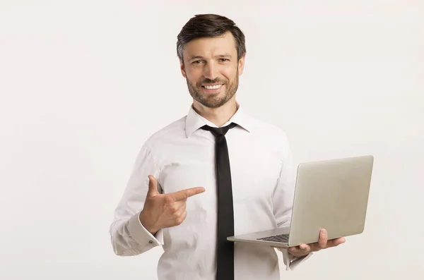 Mann zeigt mit Finger auf Laptop in der Hand, Studioaufnahme — Stockfoto