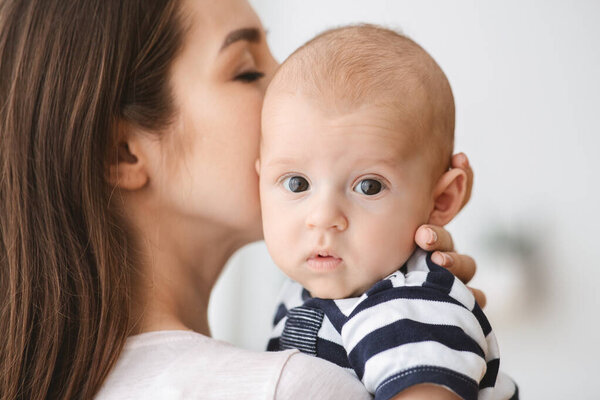 Closeup portrait of mother kissing her adorable newborn baby