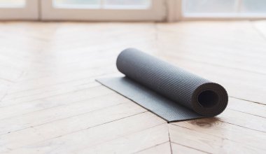 Ahşap zemin üzerinde Yoga mat kadar haddelenmiş