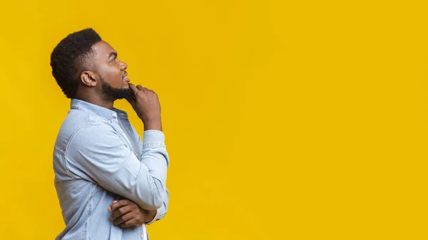 Uomo nero millenario pensare a qualcosa e guardando verso l'alto — Foto Stock