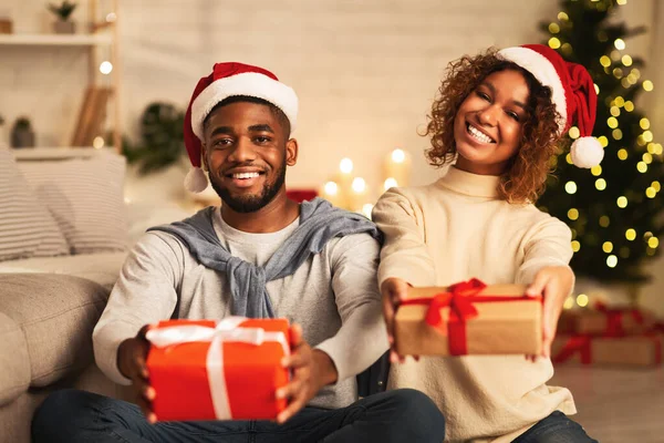 Χριστουγεννιάτικα δώρα. Μαύρο ζευγάρι κρατώντας δώρα και χαμογελώντας — Φωτογραφία Αρχείου