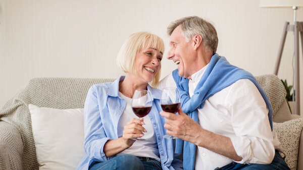 Happy retirement. Loving senior couple relaxing with wine