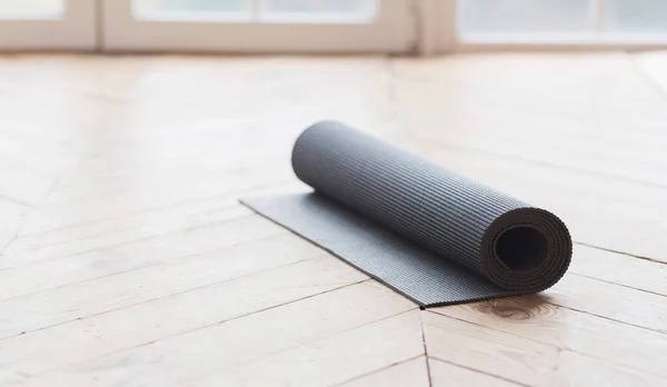 Esterilla de yoga enrollada en suelo de madera —  Fotos de Stock