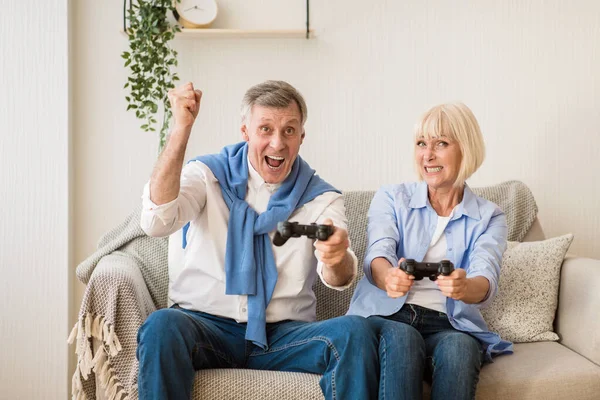 Casal maduro competindo em jogos de vídeo em casa — Fotografia de Stock