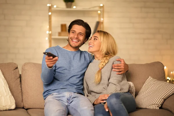 Χαριτωμένο ζευγάρι βλέποντας τηλεόραση, απολαμβάνοντας ζεστή ατμόσφαιρα στο σπίτι — Φωτογραφία Αρχείου