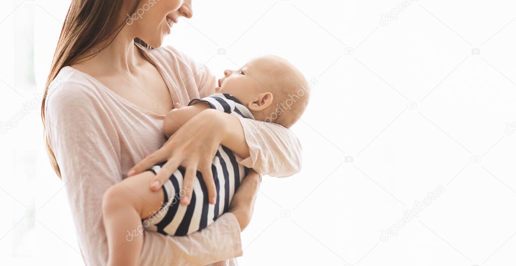 Sweet little baby lying in mothers arms