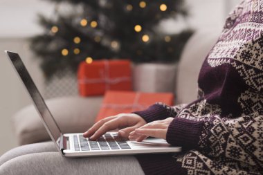 Sıcak kazaklı bir kadın Noel hediyelerini arıyor.