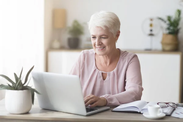 Ältere Geschäftsfrau genießt ihren Job und arbeitet von zu Hause aus — Stockfoto