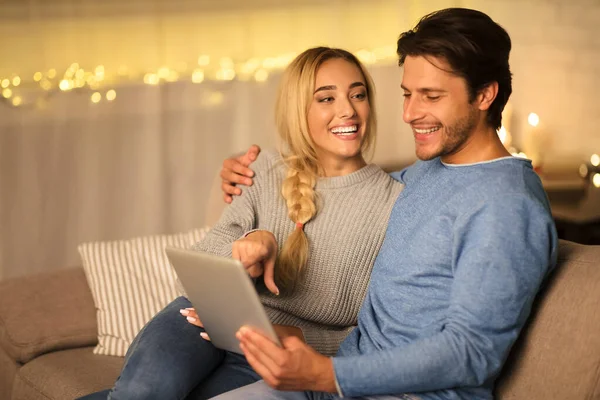 Pareja joven eligiendo la película en la tableta, descansando juntos en casa —  Fotos de Stock