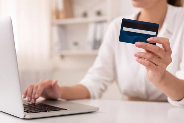 Невпізнавана офісна дівчина використовує кредитну картку та ноутбук на робочому місці — стокове фото