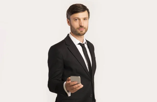 Businessman Holding Mobile Phone Standing Over White Background — Stock Photo, Image