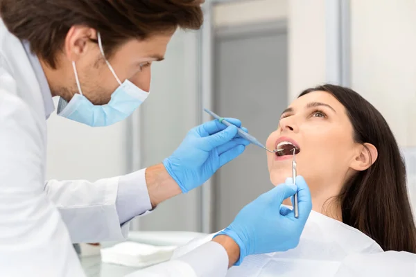 Jonge vrouw maken check-up in tandheelkundige kliniek — Stockfoto