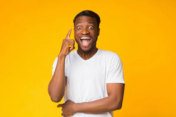 Aufgeregter afrikanisch-amerikanischer Mann zeigt mit erhobenem Zeigefinger auf Idee, Studio — Stockfoto
