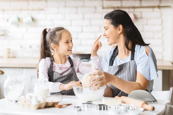 Lekfull mamma och dotter har roligt i köket medan matlagning — Stockfoto