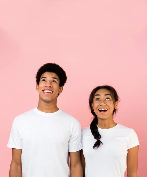 Spännande tonåring kille och flicka tittar uppåt på kopiera utrymme — Stockfoto