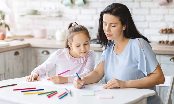Мама учит свою маленькую дочь рисовать — стоковое фото