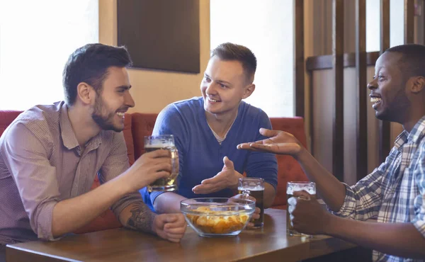 Amigos emocionados teniendo una interesante discusión mientras están sentados en el bar — Foto de Stock