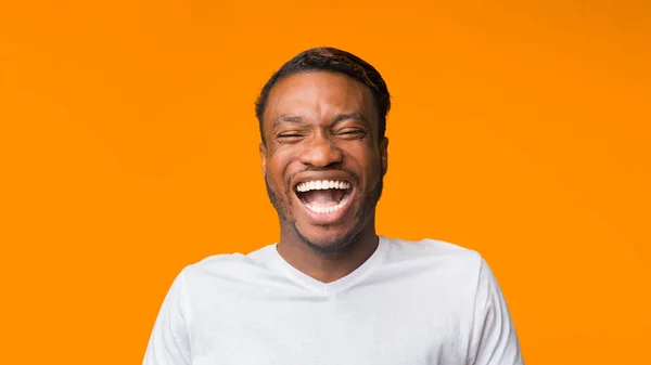 Afrikai amerikai Guy nevet álló narancssárga háttér, Panorama — Stock Fotó