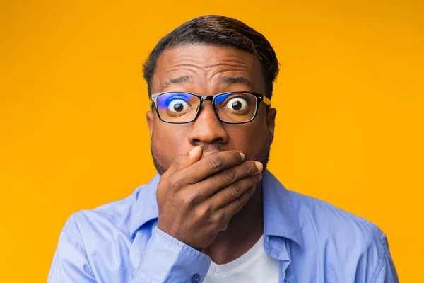 Schockierter afrikanisch-amerikanischer Typ, der den Mund mit der Hand bedeckt, gelber Hintergrund — Stockfoto