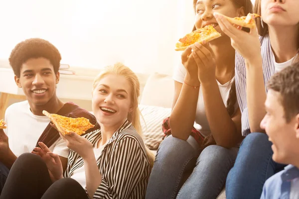 Çeşitli arkadaşlar pizza yiyor ve evde konuşuyorlar. — Stok fotoğraf