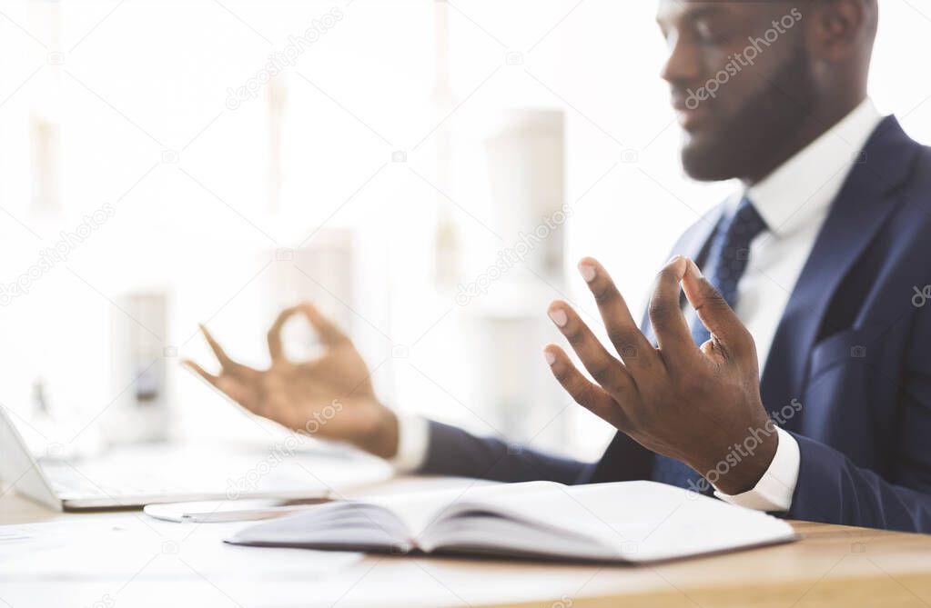 Cropped image of businessman meditating in office during working day