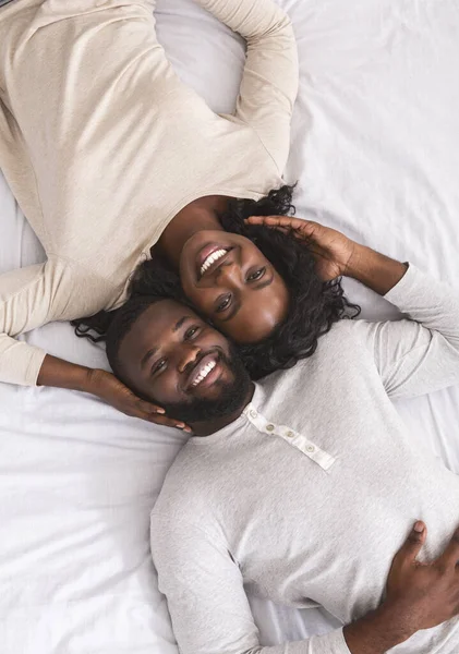 Vista dall'alto della felice coppia afro-americana sdraiata a letto — Foto Stock