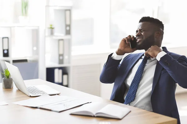 Stresszes fiatal menedzser telefonon beszél kollégáival — Stock Fotó