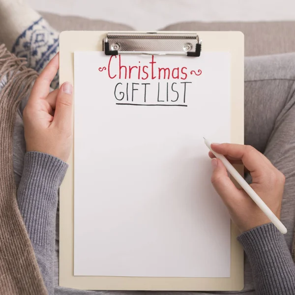 Close up of woman writing Christmas gift list for big family — Stock Photo, Image