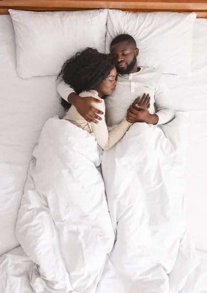 Cuplu de familie negru culcat și îmbrățișat în pat, dormind împreună . — Fotografie, imagine de stoc