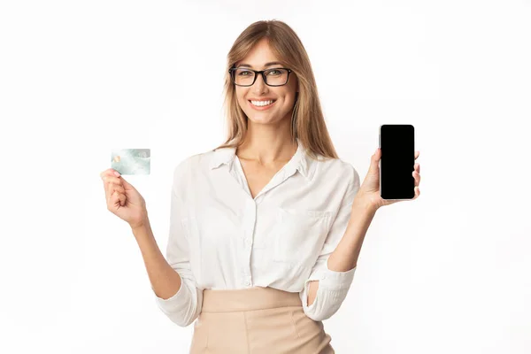 Gülümseyen Kadın Cep Telefonu ve Kredi kartını Beyaz Arkaplanda Tutuyor — Stok fotoğraf