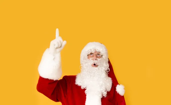 Weihnachtsmann schaut überrascht und zeigt mit dem Finger auf Kopierplatz — Stockfoto