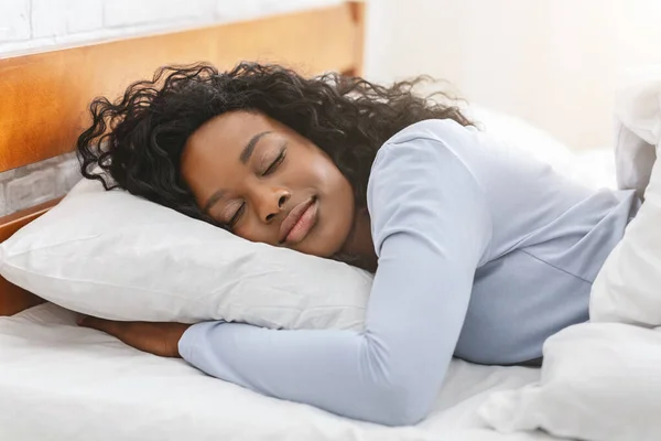 Tranquillo afro ragazza dormire a letto in mattina Foto Stock