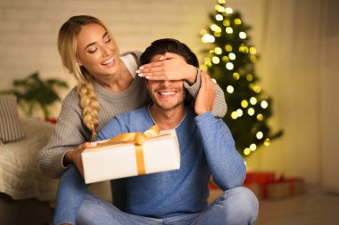 Kocasına Noel sürprizi yapan neşeli bir kadın.
