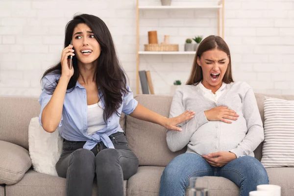 Mädchen ruft Arzt für schwangere Freundin mit Krampfanfällen im Innenraum — Stockfoto