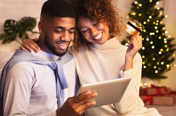 Julhelgen. Afroamerikanska par väljer presenter på surfplattan — Stockfoto