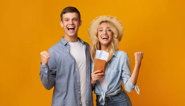 Happy couple holding passports with tickets celebrating getting a visa — Stock Photo, Image