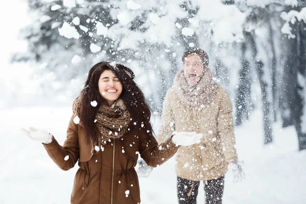Paar wirft Schnee und amüsiert sich im Winterwald — Stockfoto