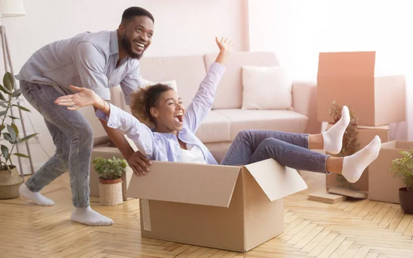 Happy Black Couple Having Fun Riding In Cardboard Boxes Indoor — Stock Photo, Image