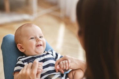 Annenin kucağında yatan sevimli yeni doğan çocuğun yakın plan portresi.
