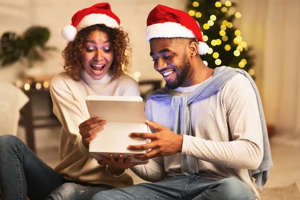 Julafton. Överraskade makar öppnar presentförpackning — Stockfoto