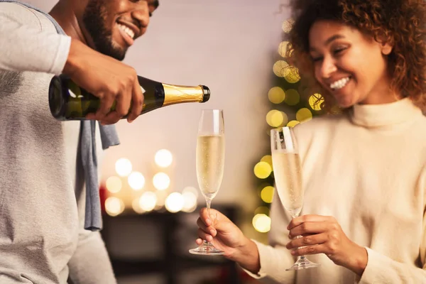 Marido derramando champanhe, celebrando o Natal com a esposa — Fotografia de Stock