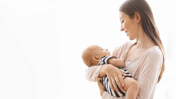 Очаровательный младенец на руках у матери на белом фоне — стоковое фото